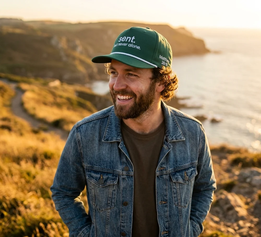 Lifestyle mockup of the green Sent hat with white embroidery